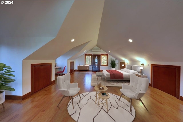 bedroom with light wood-type flooring and vaulted ceiling