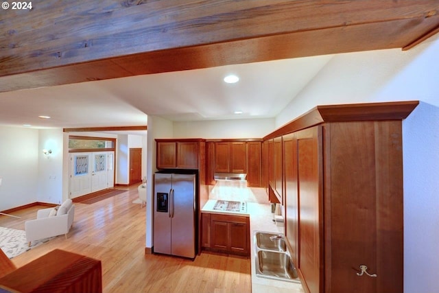 kitchen with lofted ceiling, sink, light hardwood / wood-style flooring, stainless steel fridge, and gas cooktop