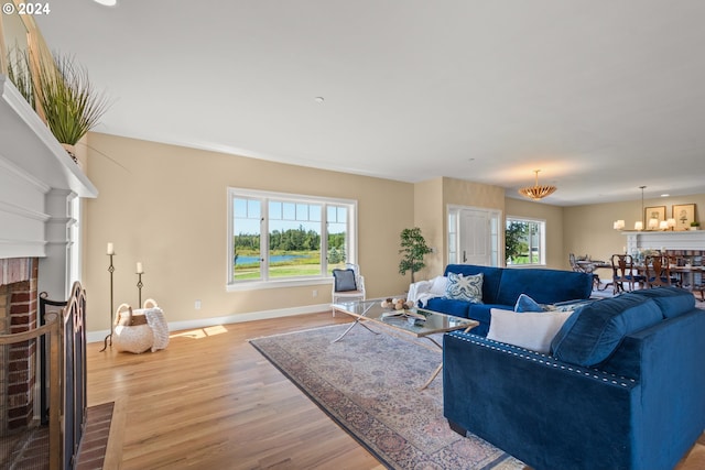 35222 NE 92nd Ct, La Center, WA 98629 - living area with an inviting chandelier, a brick fireplace, a healthy amount of sunlight, and light wood-style flooring