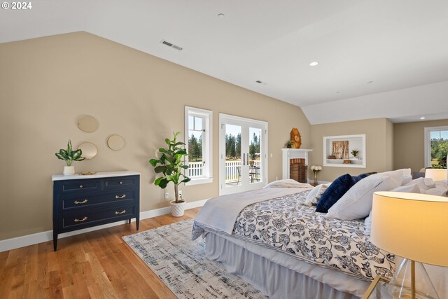 bedroom with vaulted ceiling, access to outside, french doors, and light hardwood / wood-style floors