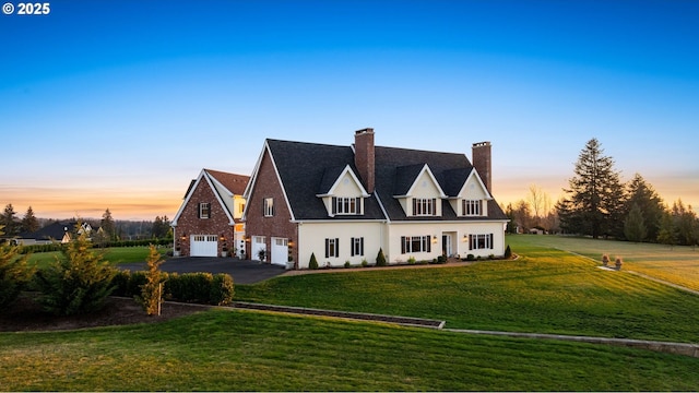 english style home with a garage and a yard