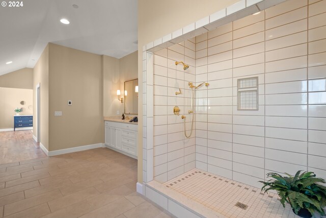 bathroom with a tile shower and vanity