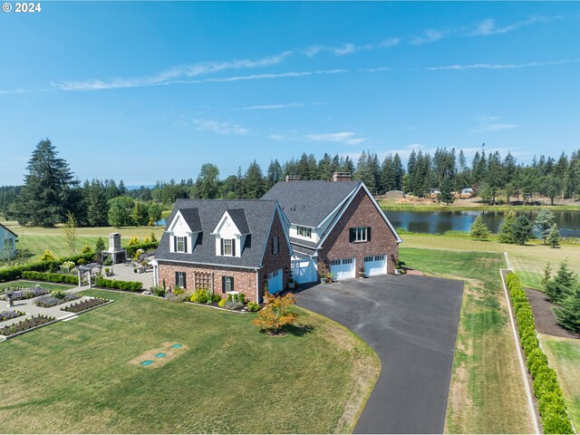 view of front of property featuring a garage, a front yard, and a water view