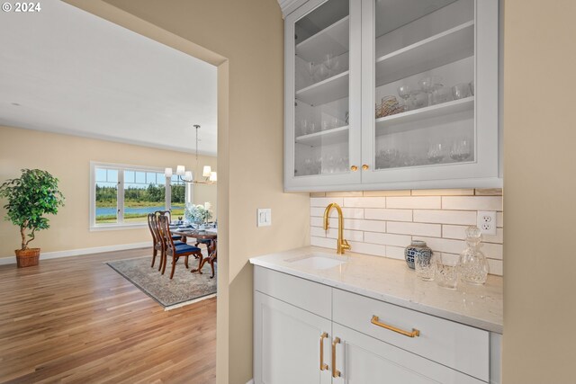 kitchen featuring dark wood-type flooring, backsplash, white cabinetry, and sink