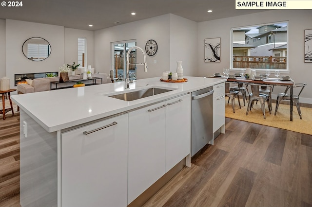 kitchen with a center island with sink, sink, stainless steel dishwasher, white cabinets, and dark hardwood / wood-style flooring