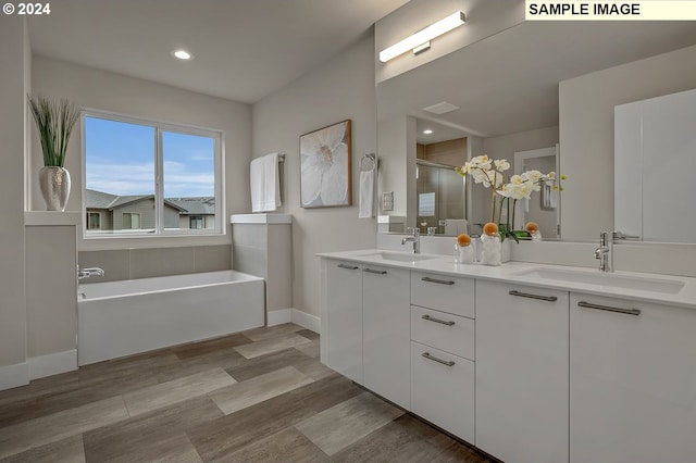 bathroom featuring vanity, hardwood / wood-style flooring, and plus walk in shower