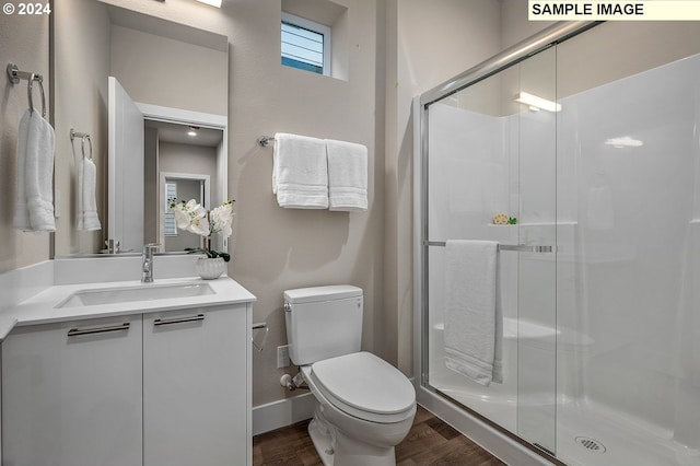 bathroom featuring vanity, wood-type flooring, toilet, and an enclosed shower