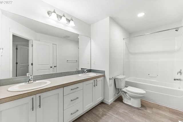 full bathroom with hardwood / wood-style floors, vanity, toilet, and washtub / shower combination