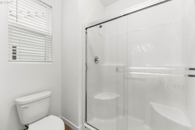 bathroom with an enclosed shower and toilet