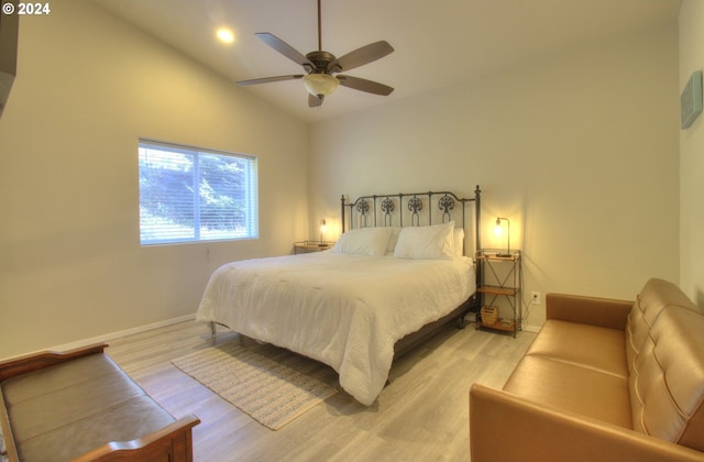 bedroom featuring light hardwood / wood-style floors, high vaulted ceiling, and ceiling fan