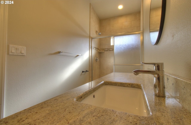 bathroom featuring vanity and a shower with shower door