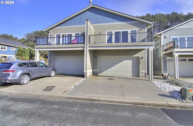 28999 Vizcaino Ct, Gold Beach, OR 97444 - view of front of house featuring a balcony, an attached garage, and driveway