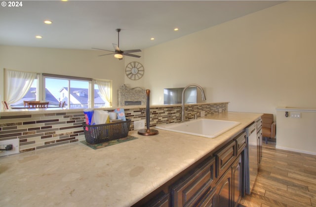 kitchen with backsplash, a fireplace, sink, and dark hardwood / wood-style floors