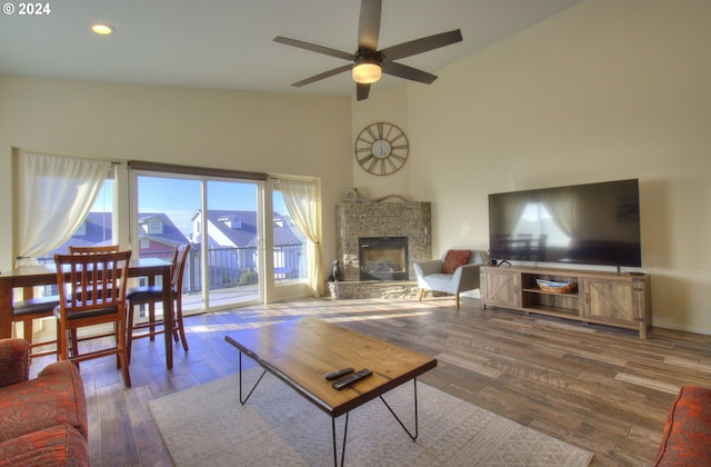 living room with ceiling fan, a fireplace, high vaulted ceiling, and hardwood / wood-style flooring