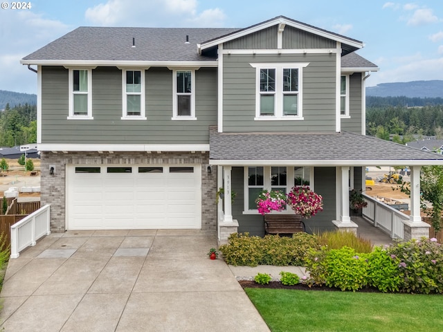 view of front of home featuring a garage, a porch, and a mountain view