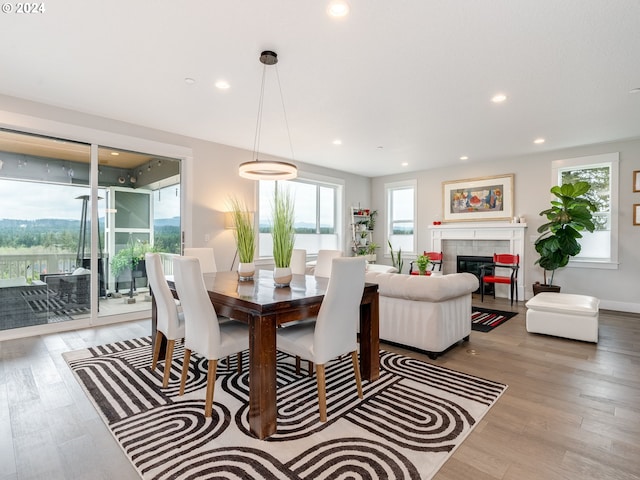 dining area with hardwood / wood-style floors and a fireplace