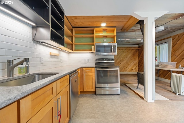 kitchen featuring radiator heating unit, light stone countertops, sink, and appliances with stainless steel finishes