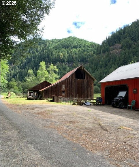 view of side of home featuring an outbuilding and a mountain view