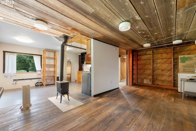 basement featuring hardwood / wood-style floors, a wood stove, and wood ceiling