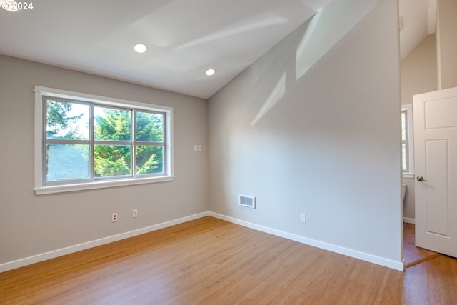 unfurnished room with light hardwood / wood-style flooring and lofted ceiling