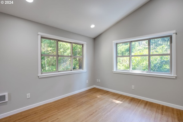 unfurnished room featuring light wood-type flooring and lofted ceiling