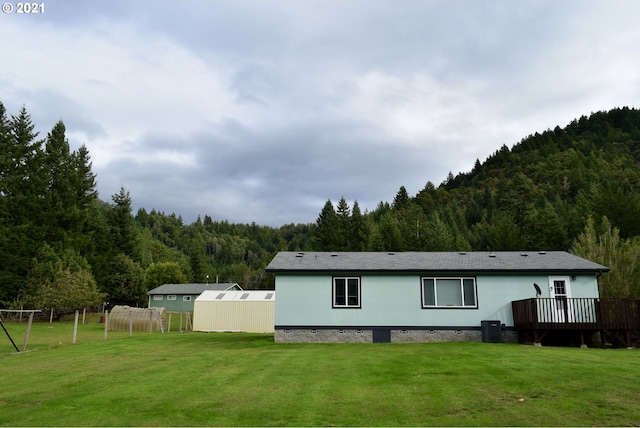 95851 Mckinnon Dr, Gold Beach, OR 97444 - back of house with a wooded view, a yard, and crawl space