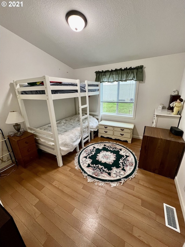 bedroom with hardwood / wood-style floors and a textured ceiling