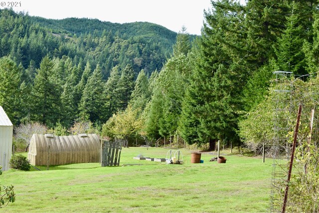 surrounding community with a rural view, a mountain view, a lawn, and an outdoor structure