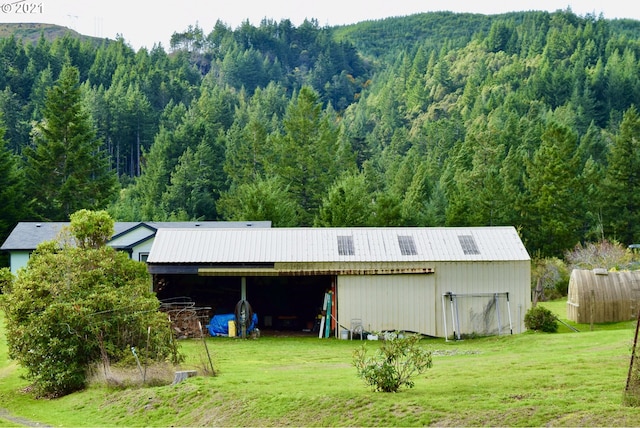 view of outbuilding with a mountain view and a lawn