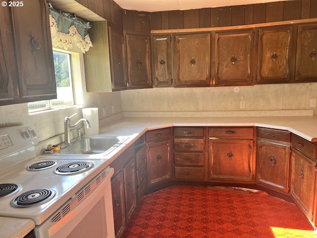 kitchen featuring tasteful backsplash, white range with electric cooktop, and sink