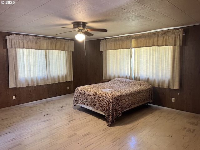 unfurnished bedroom featuring ceiling fan and wood walls