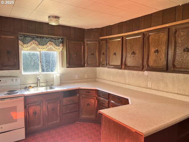 95851 Mckinnon Dr, Gold Beach, OR 97444 - kitchen with light countertops, a peninsula, a sink, and white electric range