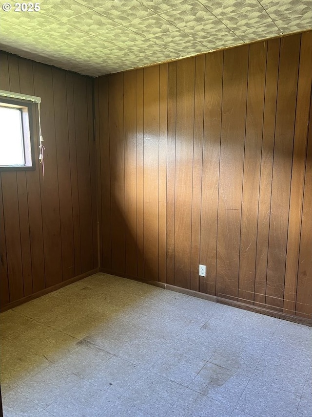 unfurnished room featuring wood walls