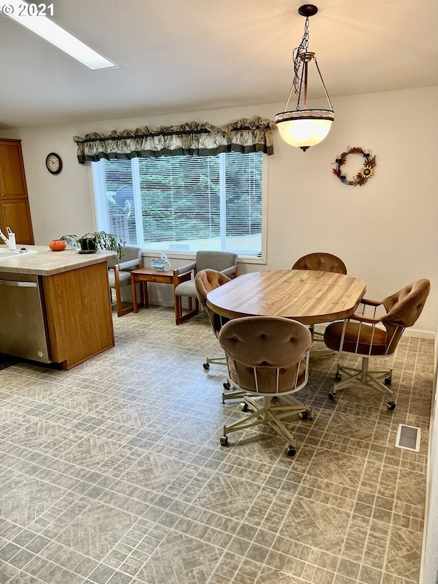 dining room featuring a skylight