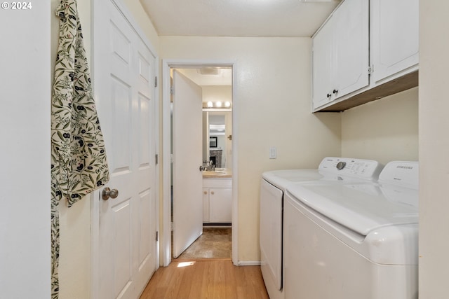 clothes washing area featuring cabinets, separate washer and dryer, sink, and light hardwood / wood-style flooring