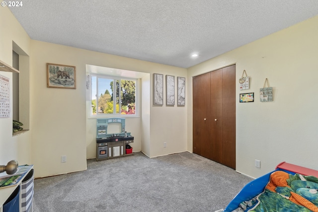 bedroom featuring light carpet, a closet, and a textured ceiling