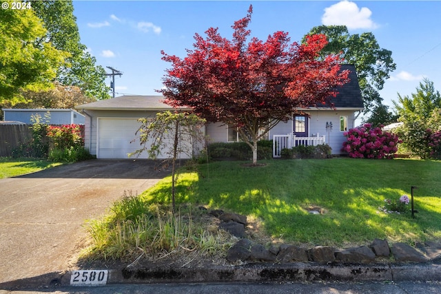 obstructed view of property with a garage and a front lawn