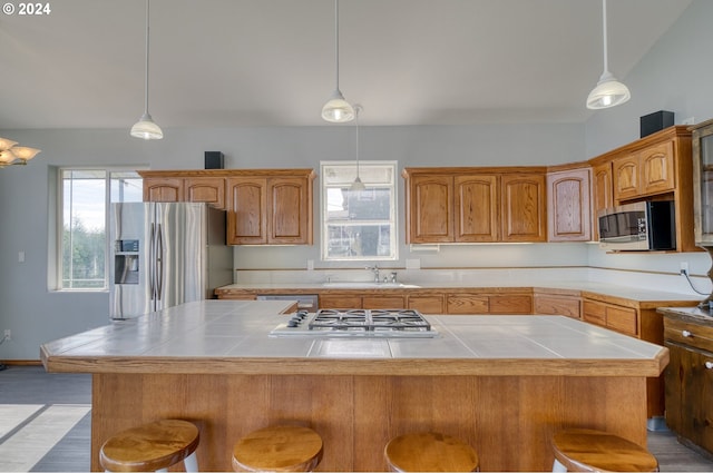 kitchen featuring appliances with stainless steel finishes, plenty of natural light, and a kitchen island