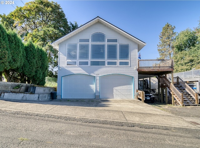 front facade with a garage and a deck