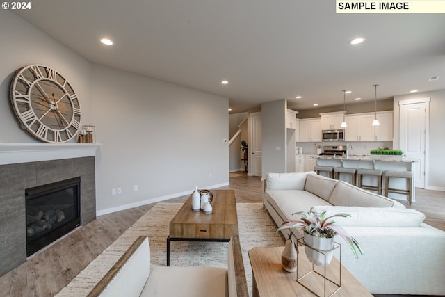 living room with light hardwood / wood-style flooring and a tile fireplace