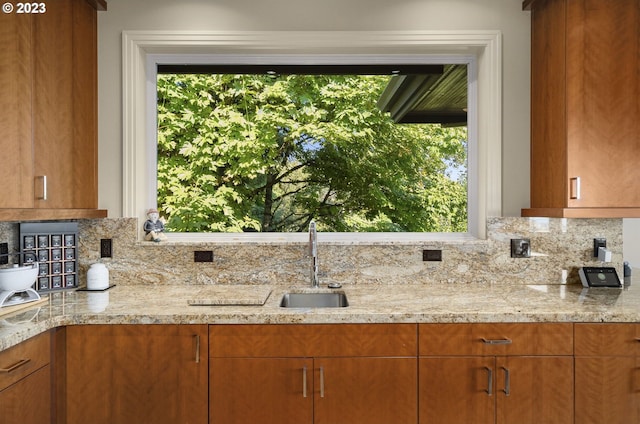 kitchen with sink, tasteful backsplash, and light stone counters