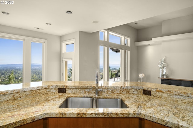 kitchen featuring sink and light stone counters