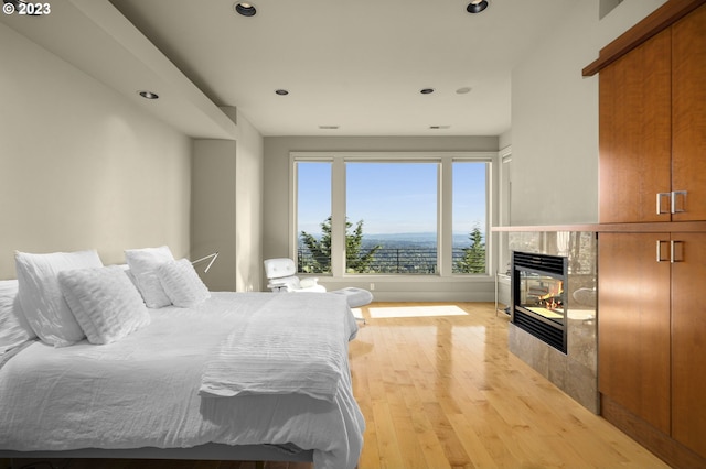 bedroom featuring a fireplace and light wood-type flooring