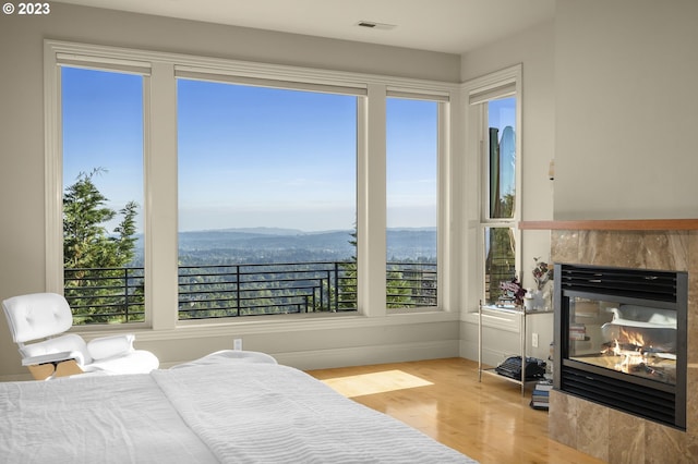 bedroom featuring a mountain view and light hardwood / wood-style flooring