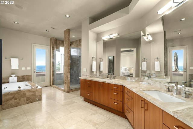 bathroom with double sink, shower with separate bathtub, tile floors, and oversized vanity