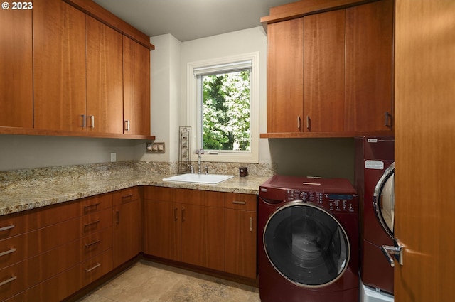 laundry room featuring light tile floors, cabinets, washer and dryer, and sink