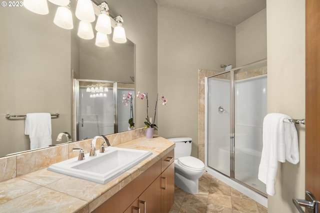 bathroom featuring toilet, tile flooring, large vanity, and an enclosed shower