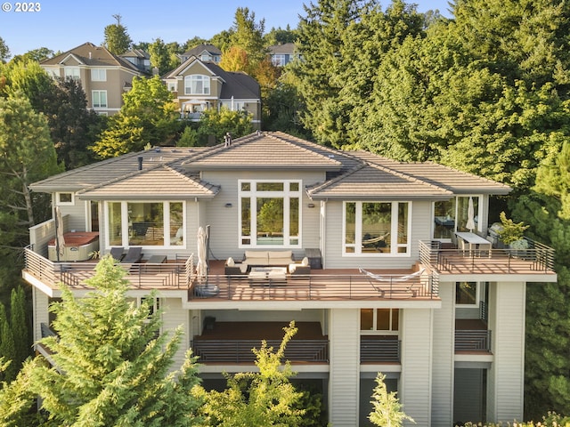 rear view of house featuring a balcony, an outdoor hangout area, and a wooden deck