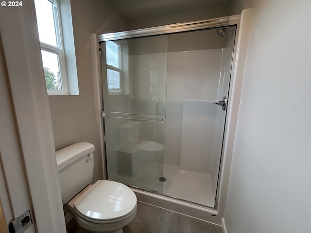 bathroom featuring toilet and an enclosed shower