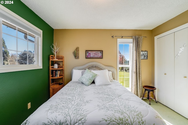 carpeted bedroom with a textured ceiling and a closet